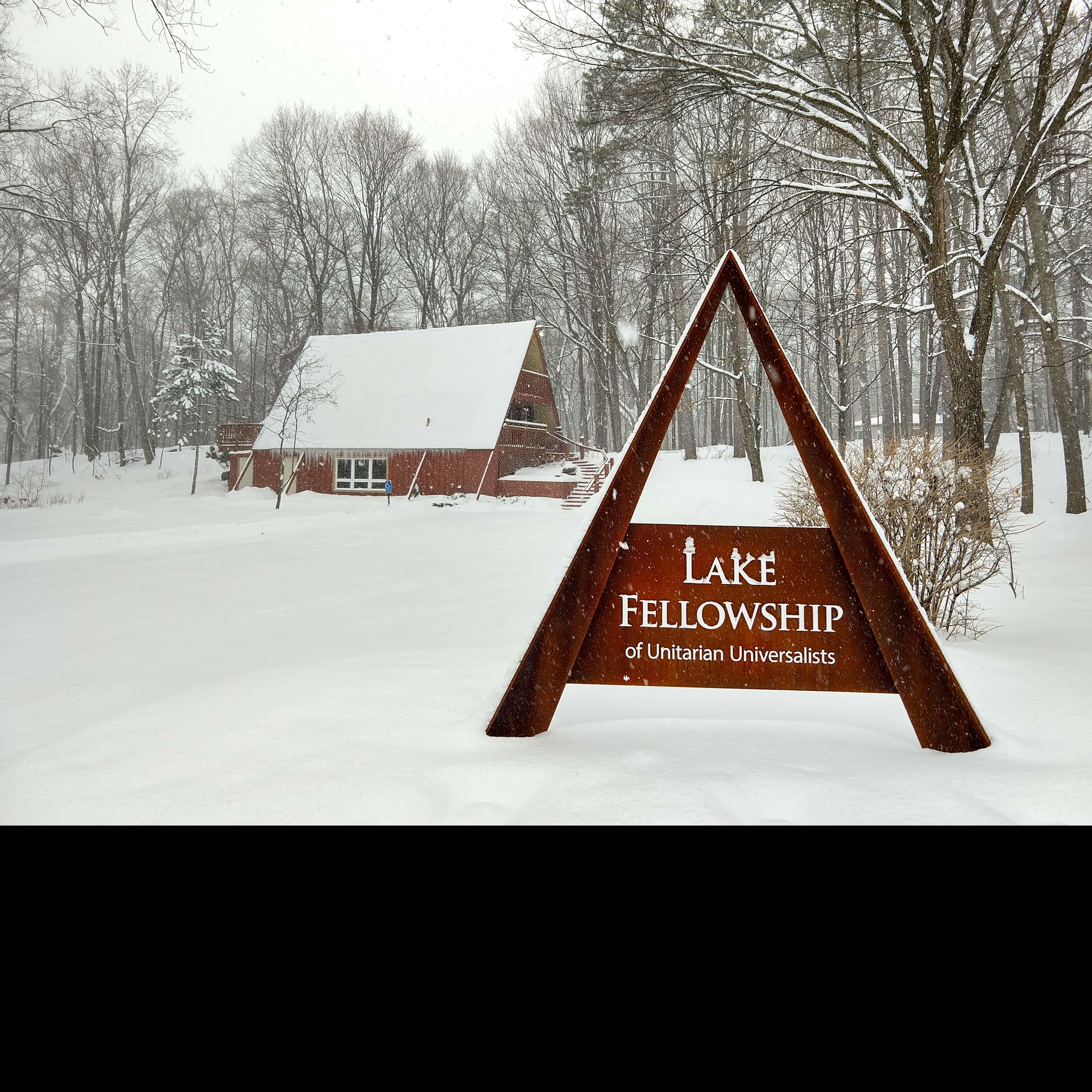 The brown Lake Fellowship A-frame sign and building covered in snow
