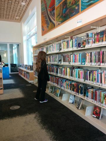 girl selects a book from the library