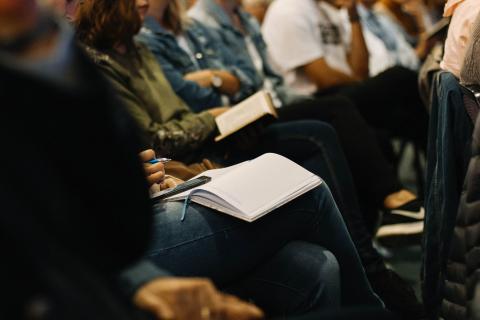 People sitting with books in their laps