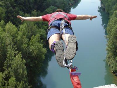 photo of person bungee jumping toward a river