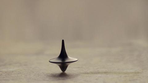 photo of a small spinning top upright on a flat surface