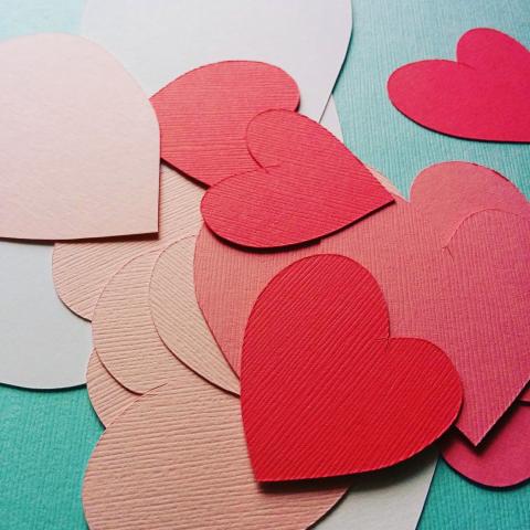 photo of multicolored paper hearts on a turquoise background