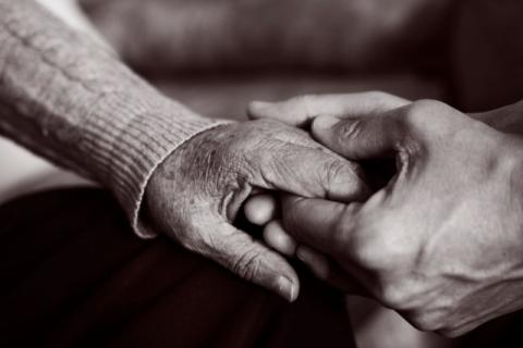 black and white photo of young hands holding hold an old hand