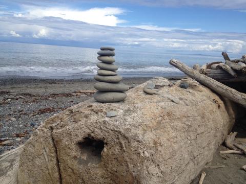 photo of a small stack of flat rocks on a beach.