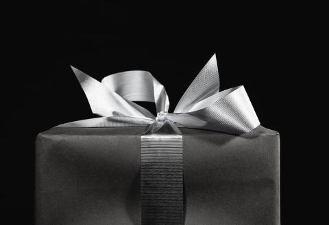 black and white photo of a gift box with a ribbon on top.