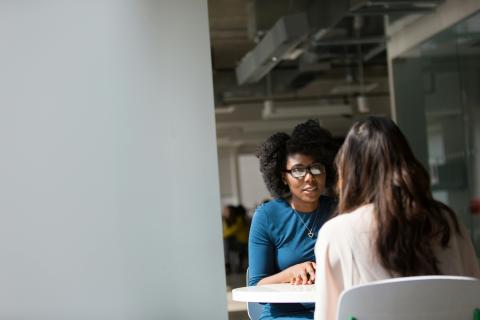 Two women sitting at a table talking