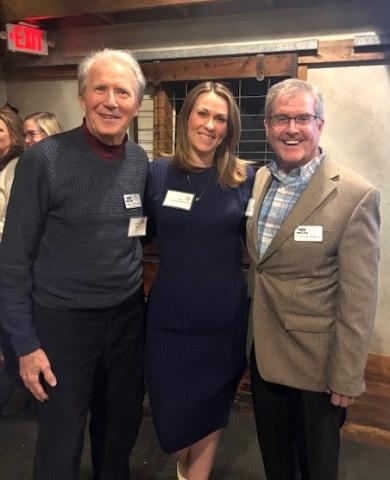 photo of three people standing together, smiling for the camera