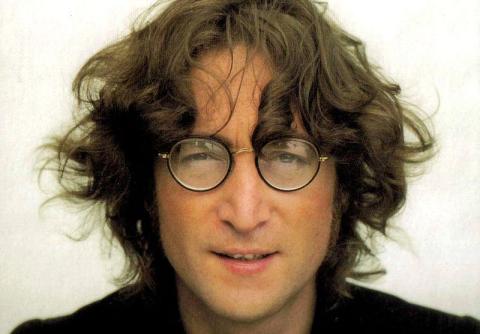 a close up photograph of John Lennon wearing his signature round glasses
