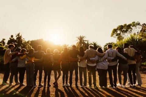 A group of people standing in a line with their arms around each other