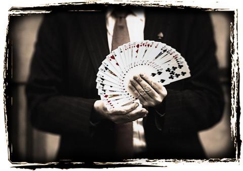 a magician holding a fanned out deck of playing cards